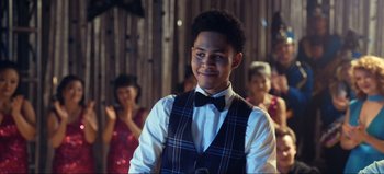 Movie still from “All Together Now” (2020), directed by Brett Haley – A man in a vest and bow tie smiling; Close Up shot, Over the shoulder angle