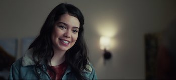 Movie still from “All Together Now” (2020), directed by Brett Haley – A young woman smiling for the camera in front of a wall; Close Up shot, Over the shoulder angle