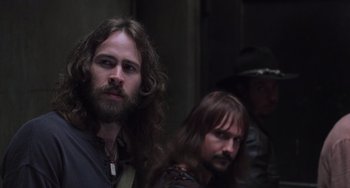 Movie still from “Almost Famous” (2000), directed by Cameron Crowe – A man with long hair and a beard standing next to another man with long brown hair; Close Up shot, Over the shoulder angle