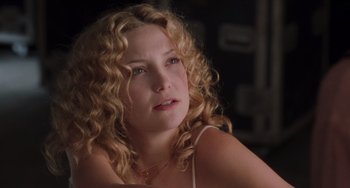 Movie still from “Almost Famous” (2000), directed by Cameron Crowe – A person with curly blonde hair; Close Up shot, Over the shoulder angle