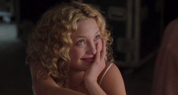 Movie still from “Almost Famous” (2000), directed by Cameron Crowe – A woman with blonde curly hair sitting in a room; Close Up shot, Over the shoulder angle