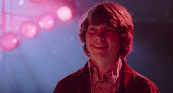 Movie still from “Almost Famous” (2000), directed by Cameron Crowe – A young man smiles brightly at the camera; Close Up shot, Low angle