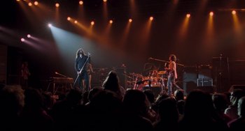 Movie still from “Almost Famous” (2000), directed by Cameron Crowe – A group of people on a stage with a band performing; Wide shot, Low angle