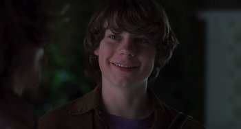 Movie still from “Almost Famous” (2000), directed by Cameron Crowe – A young man smiling for the camera with trees in the background; Close Up shot, Over the shoulder angle