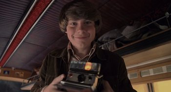 Movie still from “Almost Famous” (2000), directed by Cameron Crowe – A young man holding an old camera in a dark room; Close Up shot, Low angle