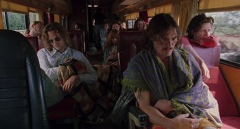 Movie still from “Almost Famous” (2000), directed by Cameron Crowe – A group of people sitting on a train car; Wide shot, Low angle