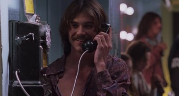 Movie still from “Almost Famous” (2000), directed by Cameron Crowe – A man holding a phone up to his ear while smiling; Close Up shot, Low angle