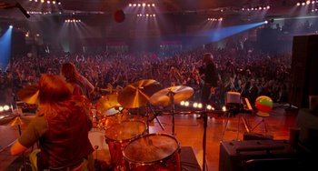 Movie still from “Almost Famous” (2000), directed by Cameron Crowe – A crowd of people watching a band play on a stage; Wide shot, High angle