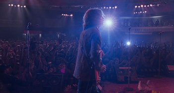 Movie still from “Almost Famous” (2000), directed by Cameron Crowe – A man with a guitar in front of an audience; Wide shot, Low angle