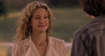 Movie still from “Almost Famous” (2000), directed by Cameron Crowe – A woman with curly hair wearing a white shirt; Close Up shot, Over the shoulder angle