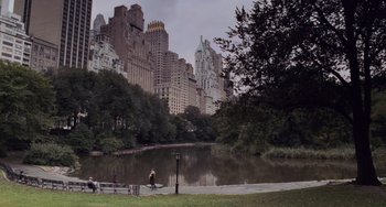 Movie still from “Almost Famous” (2000), directed by Cameron Crowe – A man sitting on a bench in front of a body of water; Extreme Wide shot, High angle