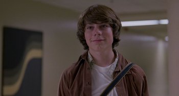 Movie still from “Almost Famous” (2000), directed by Cameron Crowe – A young man with brown hair is holding a bag; Close Up shot, Low angle