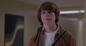 Movie still from “Almost Famous” (2000), directed by Cameron Crowe – A young man with long brown hair holding a guitar in a room; Close Up shot, Low angle