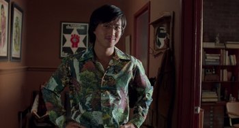 Movie still from “Almost Famous” (2000), directed by Cameron Crowe – A person standing in front of a mirror wearing a floral shirt; Medium shot, Over the shoulder angle
