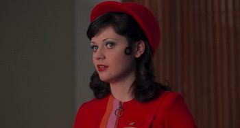 Movie still from “Almost Famous” (2000), directed by Cameron Crowe – A woman in a red suit and a red hat; Close Up shot, Overhead angle