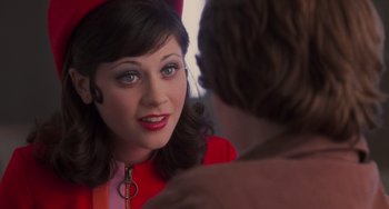 Movie still from “Almost Famous” (2000), directed by Cameron Crowe – A woman in a red outfit looking at a man in a brown suit; Close Up shot, Over the shoulder angle