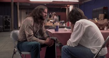 Movie still from “Almost Famous” (2000), directed by Cameron Crowe – Two men sitting at a table talking to each other; Medium shot, Over the shoulder angle