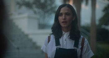 Movie still from “Along for the Ride” (2022), directed by Sofia Alvarez – A woman in a white shirt and black overalls; Close Up shot, Over the shoulder angle