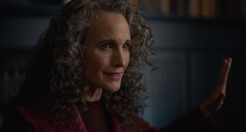 Movie still from “Along for the Ride” (2022), directed by Sofia Alvarez – An older woman with long curly grey hair looking at the camera; Close Up shot, Over the shoulder angle