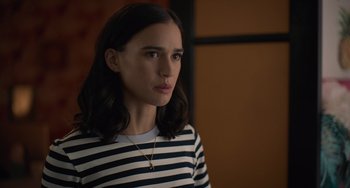 Movie still from “Along for the Ride” (2022), directed by Sofia Alvarez – A woman in a striped shirt is looking at the camera; Close Up shot, Over the shoulder angle