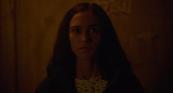 Movie still from “Along for the Ride” (2022), directed by Sofia Alvarez – A woman with long dark hair is in the dark; Close Up shot, Low angle