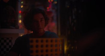 Movie still from “Along for the Ride” (2022), directed by Sofia Alvarez – A man sitting in front of a computer in the dark; Close Up shot, Over the shoulder angle