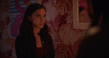 Movie still from “Along for the Ride” (2022), directed by Sofia Alvarez – A woman standing in front of a mirror in a room; Close Up shot, Over the shoulder angle