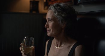Movie still from “Along for the Ride” (2022), directed by Sofia Alvarez – An older woman holding a glass of white wine; Close Up shot, Over the shoulder angle
