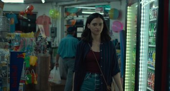 Movie still from “Along for the Ride” (2022), directed by Sofia Alvarez – A young woman is walking through a store; Medium shot, Over the shoulder angle