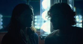 Movie still from “Along for the Ride” (2022), directed by Sofia Alvarez – A man and a woman face to face in front of a window; Close Up shot, Over the shoulder angle