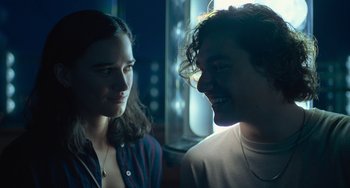 Movie still from “Along for the Ride” (2022), directed by Sofia Alvarez – A man and a woman smiling at each other; Close Up shot, Over the shoulder angle