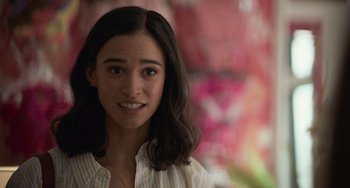 Movie still from “Along for the Ride” (2022), directed by Sofia Alvarez – A young woman with long dark brown hair wearing a striped shirt; Close Up shot, Over the shoulder angle