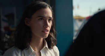 Movie still from “Along for the Ride” (2022), directed by Sofia Alvarez – A woman with long dark hair wearing a striped shirt; Close Up shot, Over the shoulder angle