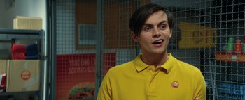 Movie still from “American Carnage” (2022), directed by Diego Hallivis – A man in a yellow shirt is standing in front of a fence; Close Up shot, Over the shoulder angle