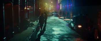 Movie still from “American Carnage” (2022), directed by Diego Hallivis – Two people walking down a street at night; Extreme Wide shot, High angle