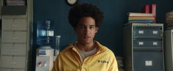 Movie still from “American Carnage” (2022), directed by Diego Hallivis – A man in a yellow jacket with a clock in the background; Close Up shot, Low angle