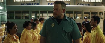 Movie still from “American Carnage” (2022), directed by Diego Hallivis – A group of people standing in front of a building; Medium shot, Over the shoulder angle