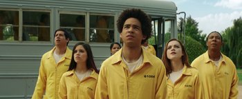 Movie still from “American Carnage” (2022), directed by Diego Hallivis – A group of young people in prison uniforms; Medium shot, Low angle