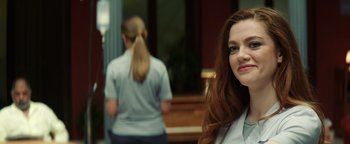 Movie still from “American Carnage” (2022), directed by Diego Hallivis – A woman standing in front of another woman in front of a piano; Close Up shot, Over the shoulder angle