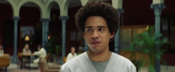 Movie still from “American Carnage” (2022), directed by Diego Hallivis – A young man with a curly afro is looking at the camera; Close Up shot, Low angle