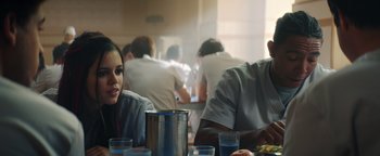 Movie still from “American Carnage” (2022), directed by Diego Hallivis – A group of people sitting at a table with drinks; Medium shot, Over the shoulder angle