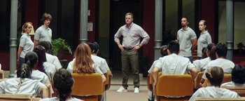 Movie still from “American Carnage” (2022), directed by Diego Hallivis – A man standing in front of a group of people; Wide shot, Low angle