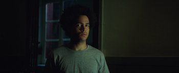 Movie still from “American Carnage” (2022), directed by Diego Hallivis – A young man is looking into the distance; Close Up shot, Low angle