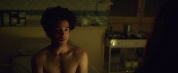 Movie still from “American Carnage” (2022), directed by Diego Hallivis – A man with a beard is sitting in a bathroom; Close Up shot, Over the shoulder angle
