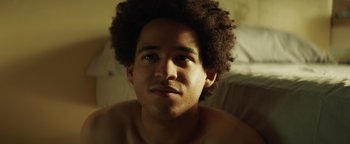 Movie still from “American Carnage” (2022), directed by Diego Hallivis – A young man with a beard is looking at the camera; Close Up shot, Low angle