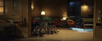 Movie still from “American Carnage” (2022), directed by Diego Hallivis – A group of wheelchairs lined up against a wall in a room; Wide shot, High angle