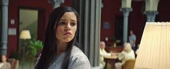 Movie still from “American Carnage” (2022), directed by Diego Hallivis – A young woman standing in front of a pillar; Close Up shot, Over the shoulder angle