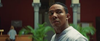 Movie still from “American Carnage” (2022), directed by Diego Hallivis – A person with a plant in the background; Close Up shot, Low angle