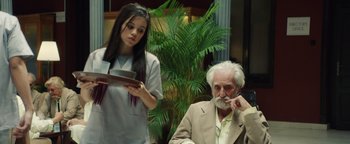 Movie still from “American Carnage” (2022), directed by Diego Hallivis – An older man sitting next to an older woman; Medium shot, Low angle