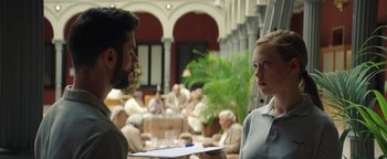 Movie still from “American Carnage” (2022), directed by Diego Hallivis – A man and a woman talking to each other in an indoor setting; Medium shot, Over the shoulder angle